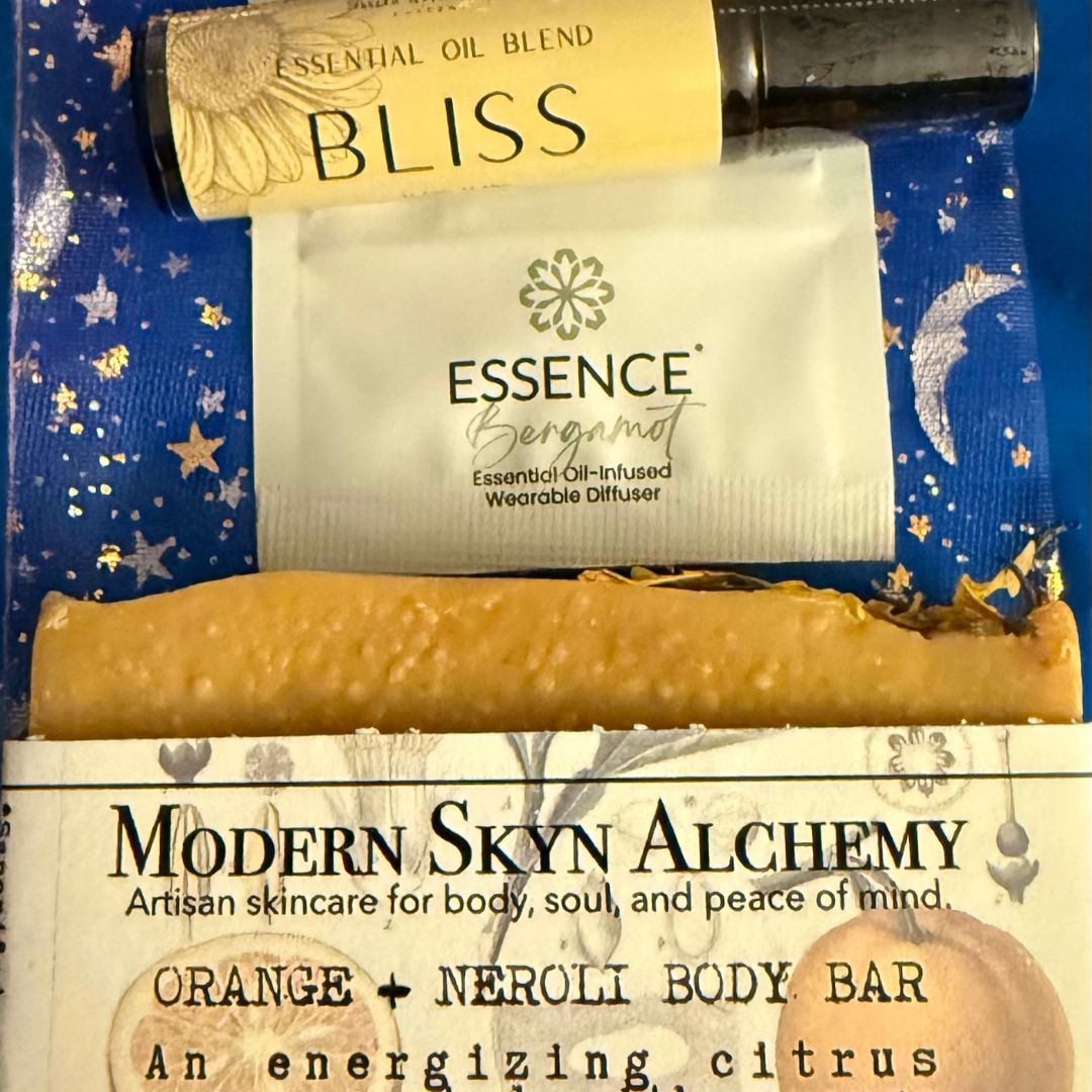 Essence Bergamot essential oil blend, Bliss, and Modern Skyn Alchemy products on a blue background.