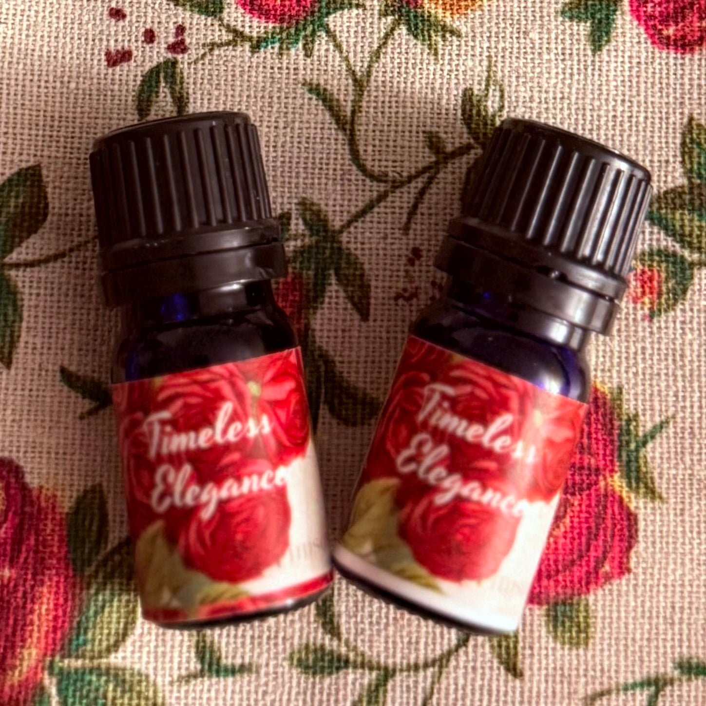 Two bottles of 'Timeless Elegance' on a floral fabric background