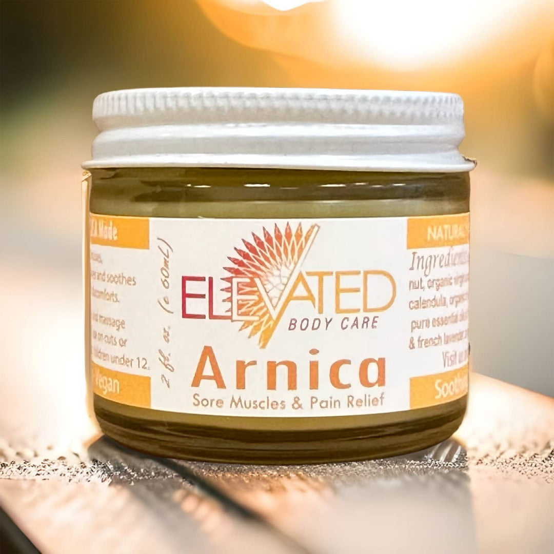 Jar of Elevated Body Care Arnica on a wooden surface with a blurred background