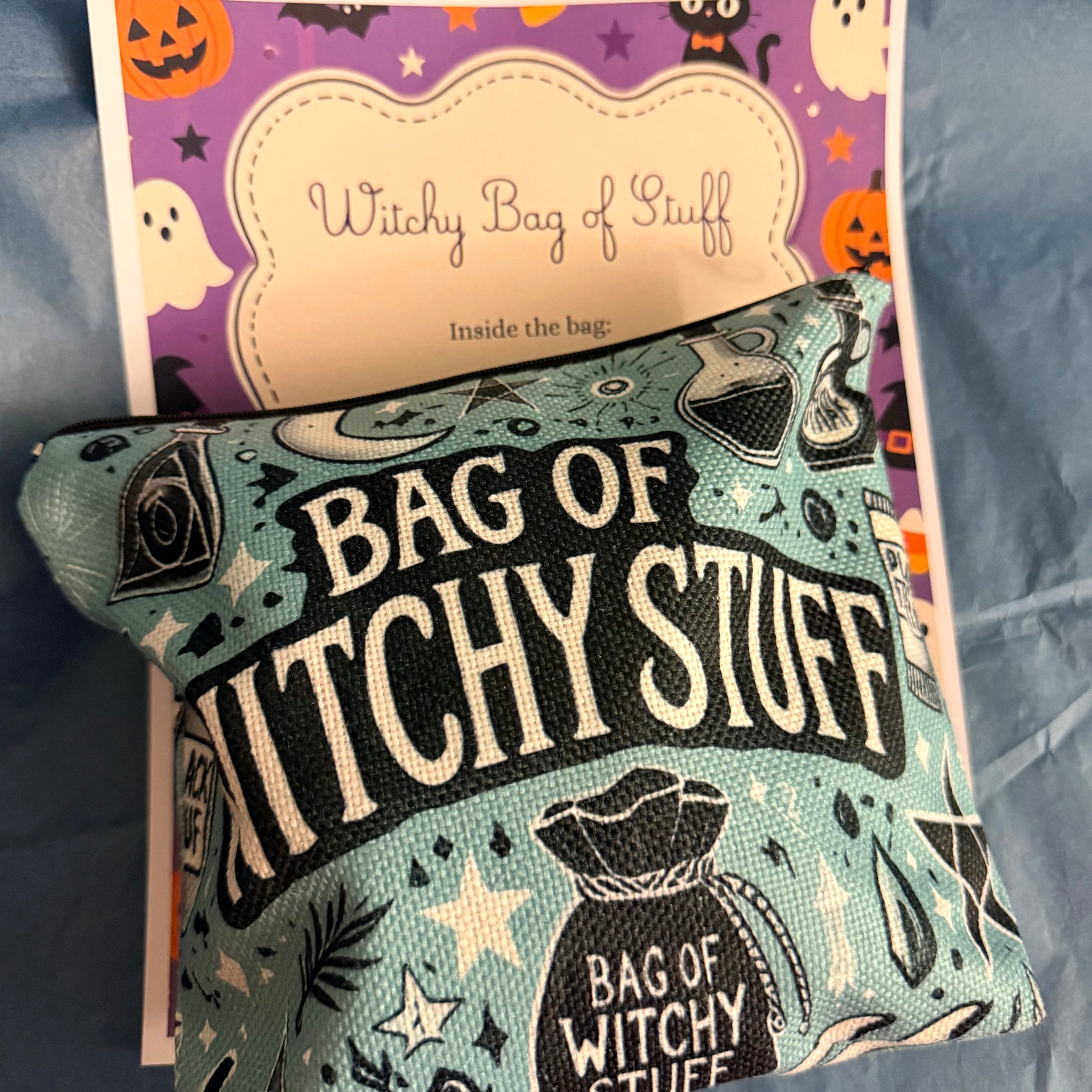A small fabric pouch printed with 'BAG OF WITCHY STUFF' in large cream letters over a pale blue-green background with occult illustrations, placed in front of a matching printed insert card that reads 'Witchy Bag of Stuff.' No person, animal, or real environment is present; this is a styled product shot, so subject_type is Product/Packaging.
