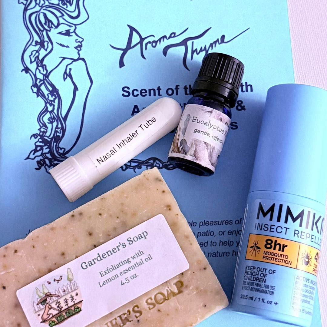 A curated flat-lay of wellness and home fragrance products on a light blue printed card: a bar of speckled Gardener's Soap, a white Nasal Inhaler Tube, a small dark bottle labeled Eucalyptus Oil, and a light blue Mimiki Insect Repellent can.